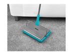 A Belray carpet sweeper cleans a grey carpet.