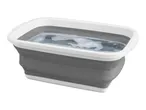 Collapsible washing up bowl, grey and white, filled with soapy water.