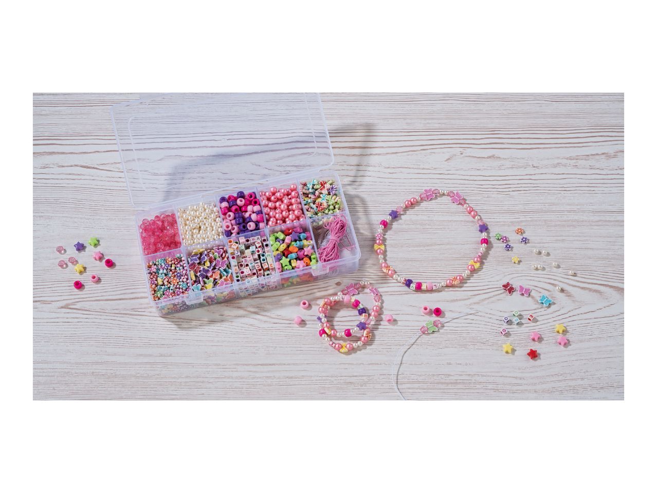 Bead kit with various colorful beads, including pearls, stars, and letters, and finished jewelry.