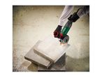 Angle grinder cutting a concrete slab, creating sparks, held by gloved hands.