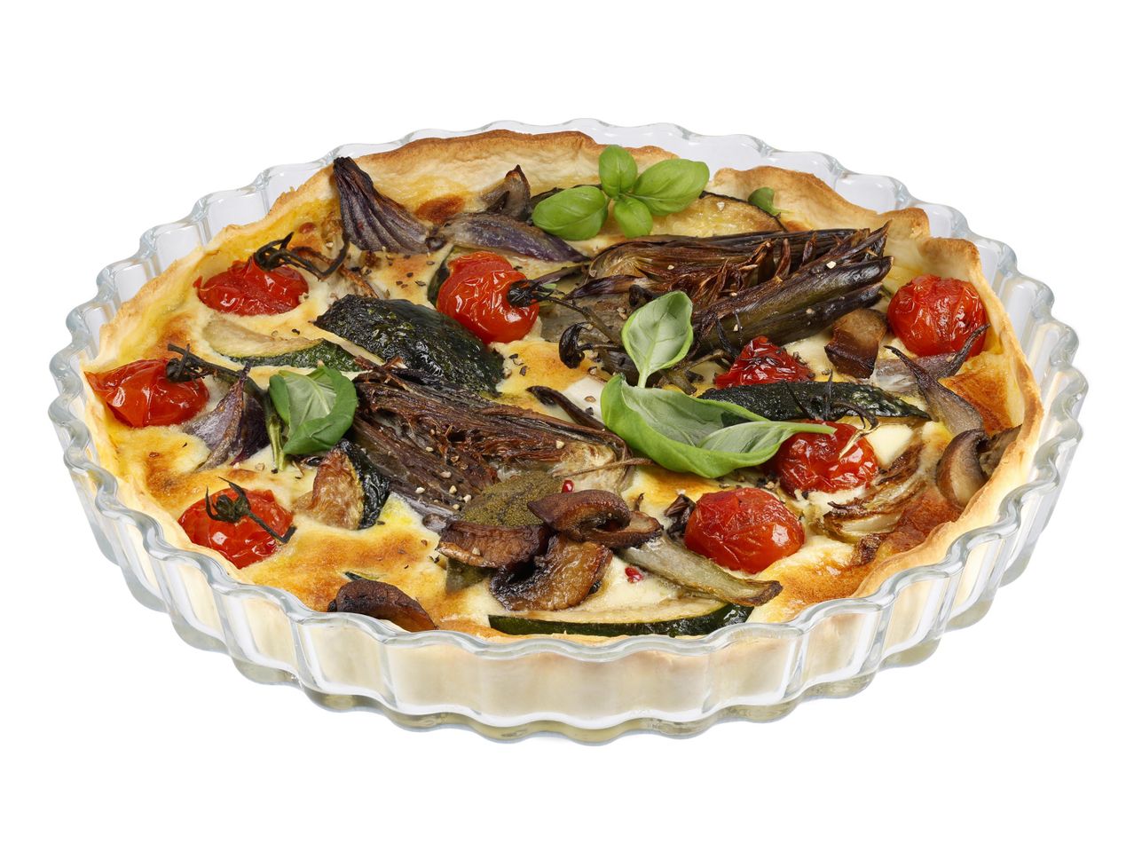 Zöldséges quiche üveg sütőformában, fehér háttér előtt.
