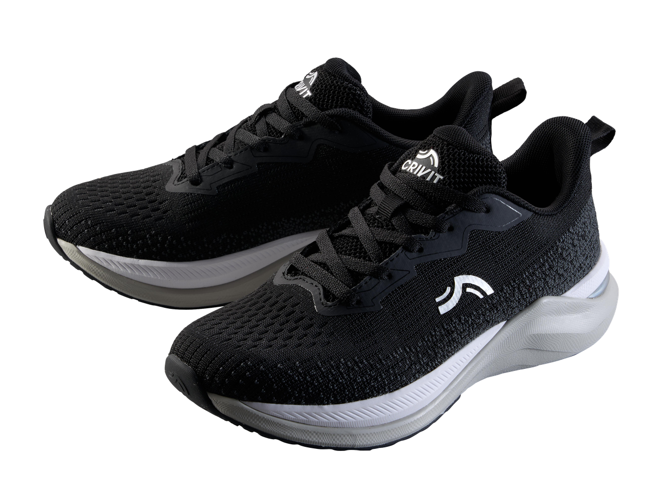 Fekete futócipők fehér talppal, fekete háttér előtt.