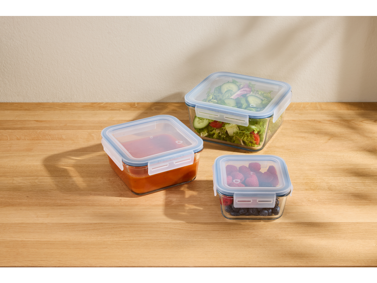 Δοχεία αποθήκευσης τροφίμων Silvercrest® με σαλάτα, σάλτσα και μούρα σε ξύλινο τραπέζι.