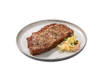 Bife Angus Rib Eye temperado com salada de couve num prato.