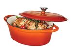 Orange enameled cast iron Dutch oven with a cooked roast and vegetables inside.