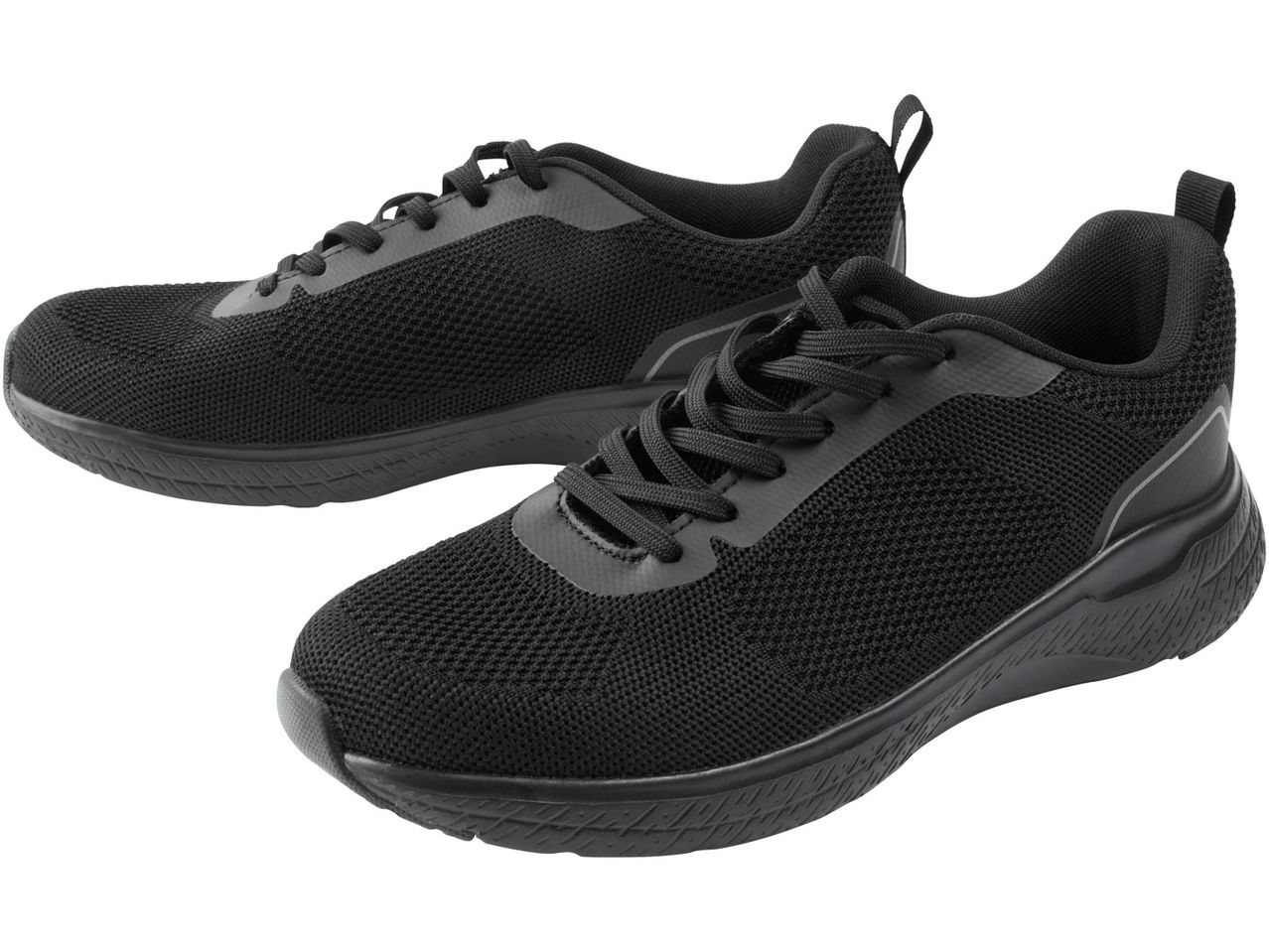 Due scarpe da ginnastica nere con lacci, una leggermente dietro l'altra.