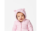 Baby in a pink lightweight jacket with bear ears.