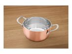 Copper-colored stainless steel pot with measurement markings on a wooden surface.