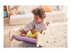 Happy child playing in a wooden rocker in a living room.