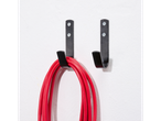 Red cable hanging on two black wall hooks.