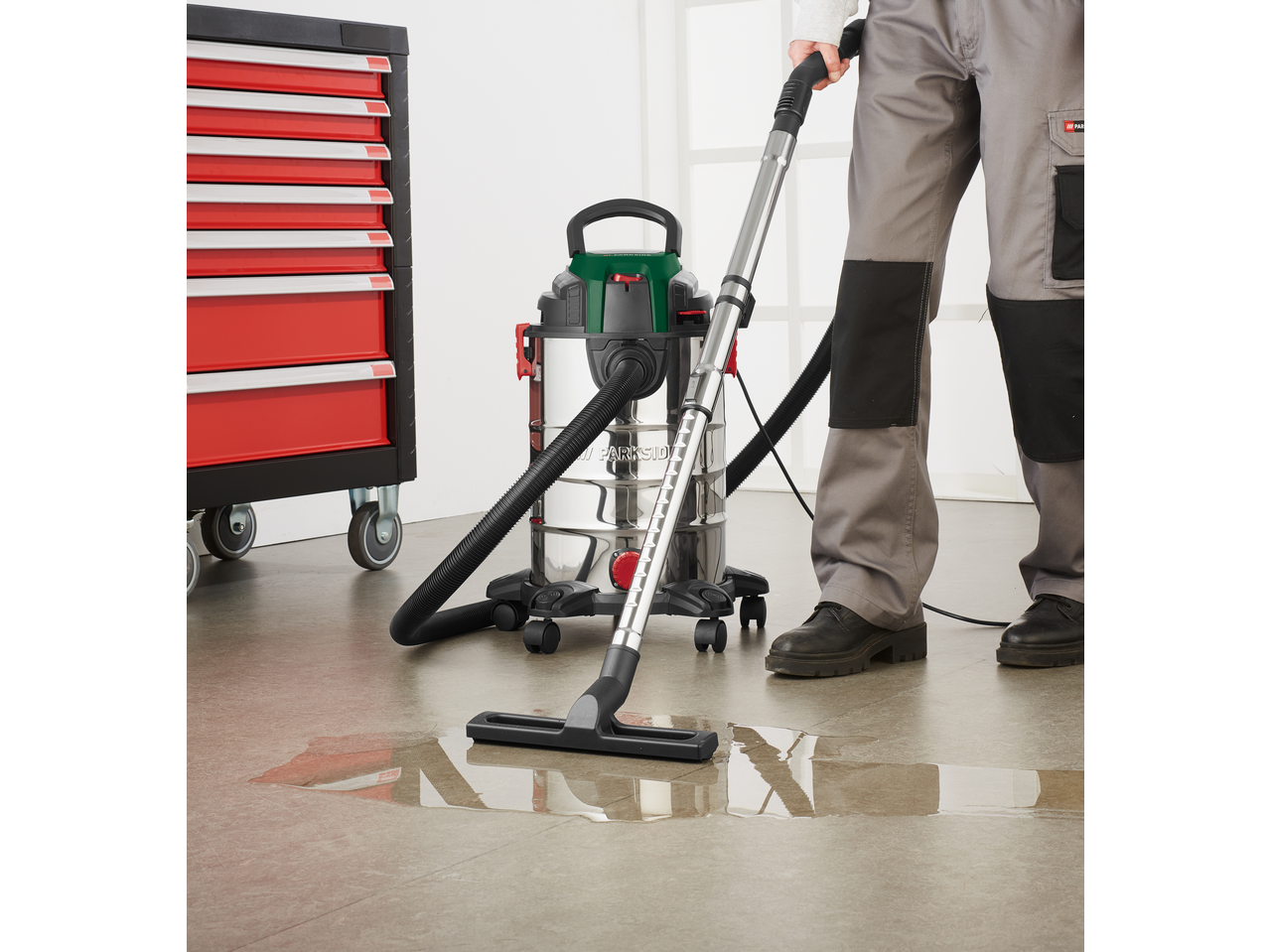 PARKSIDE® 1400W Wet & Dry Vacuum Cleaner cleaning a puddle on a workshop floor.