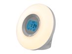 Circular wake-up light alarm clock with a digital display and warm glowing light