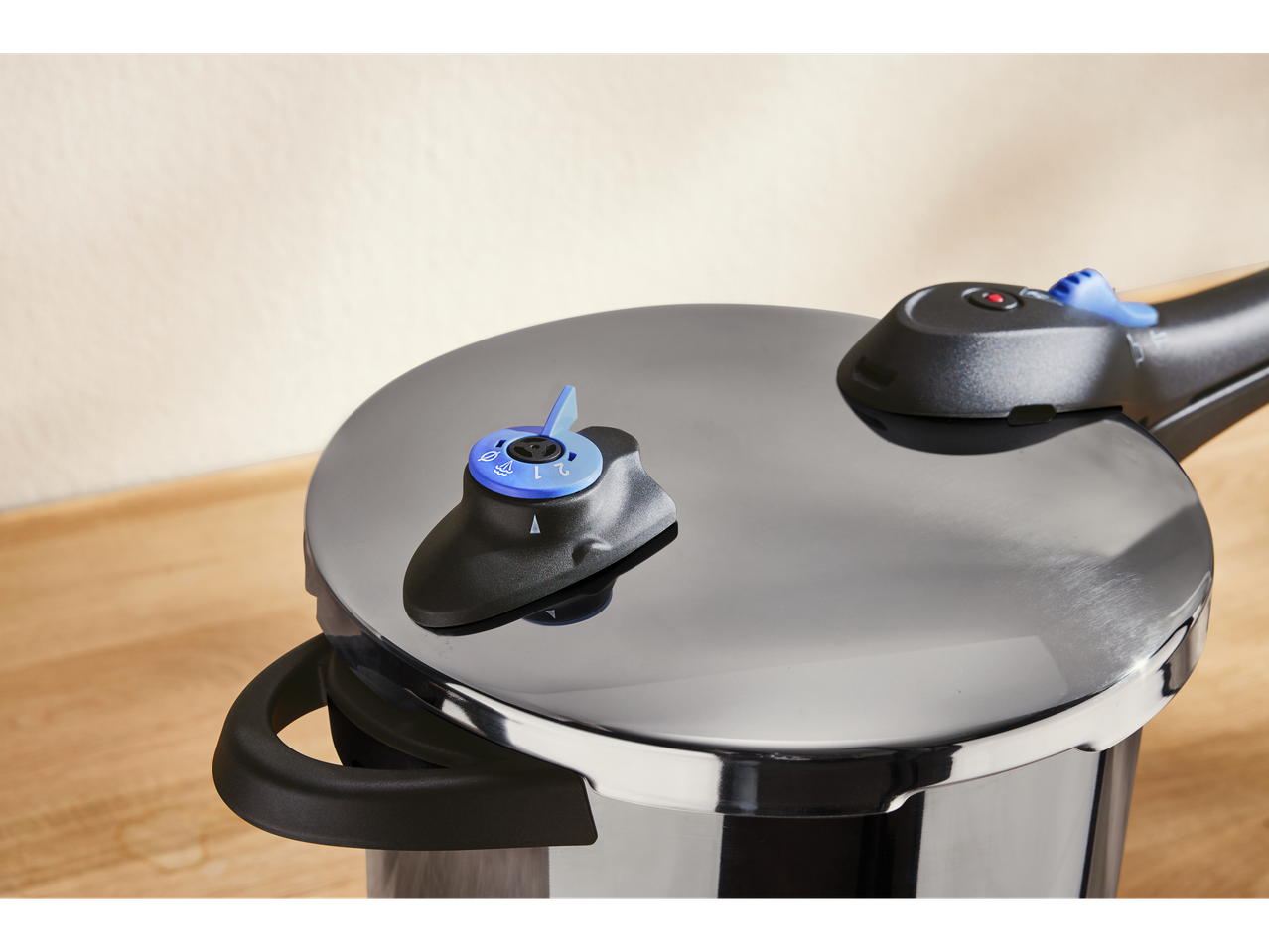 Oală sub presiune SILVERCREST cu buton de control albastru pe o masă de lemn.