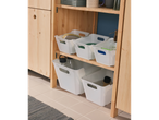 White plastic storage bins neatly organized on a light wood shelf unit.