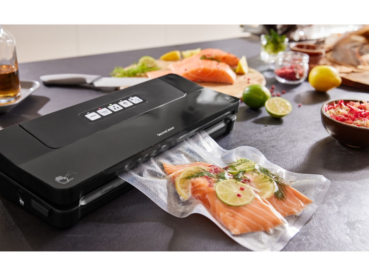 A SilverCrest vacuum sealer is sealing a bag of salmon fillets with lime and dill.