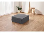Un materasso pieghevole grigio scuro su un pavimento in legno chiaro in una stanza luminosa.