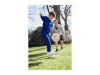 Boy in blue tracksuit kicking a football with a man in a grey hoodie in a garden.