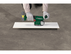 Pessoa a lixar uma tábua branca com uma lixadeira Parkside 20 V.