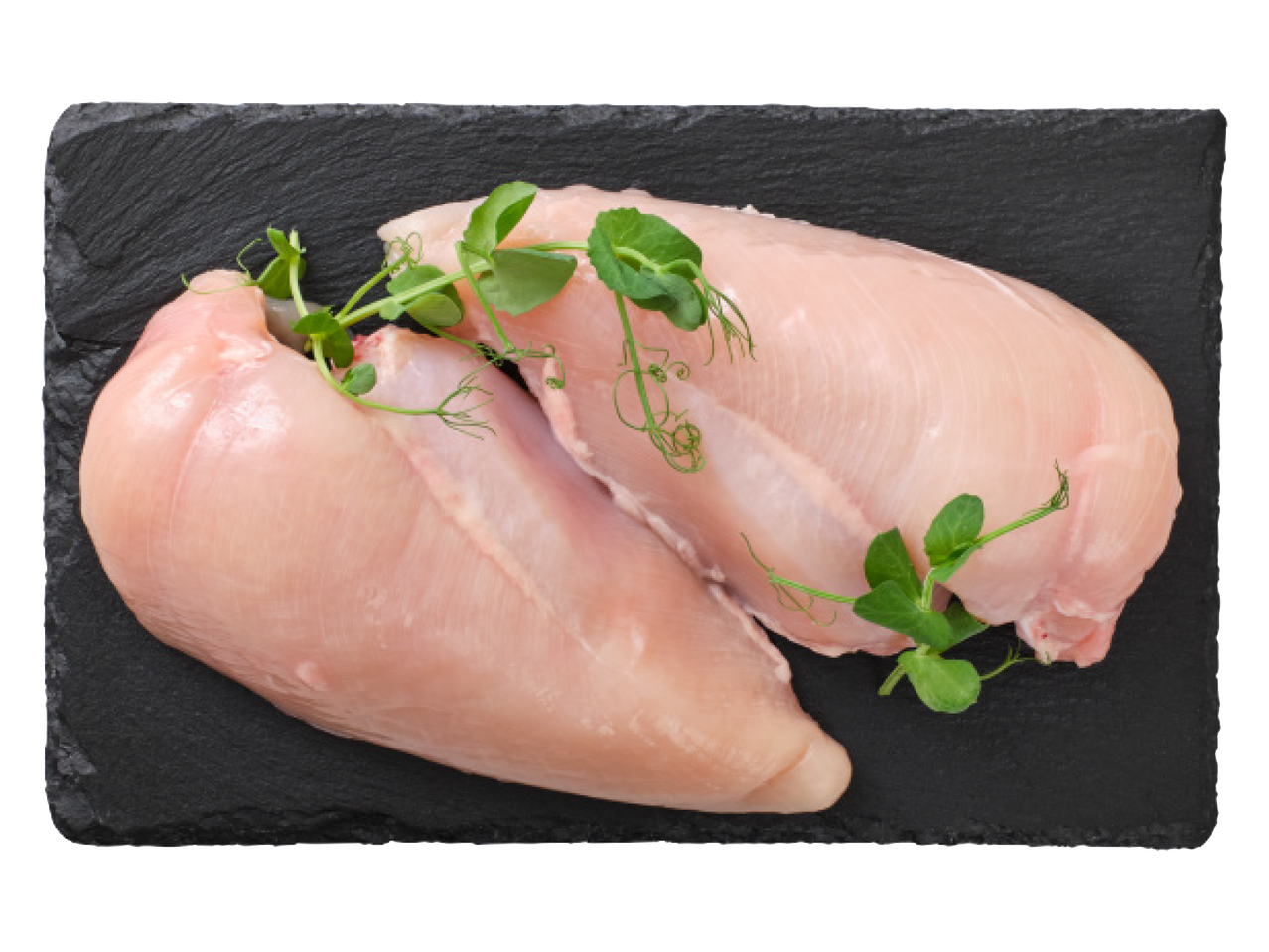 Jēla vistas fileja ar zaļumiem uz melna akmens dēlīša.