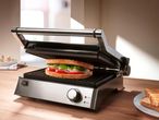 Egy rozsdamentes acél panini sütő készülékben készülő szendvics.