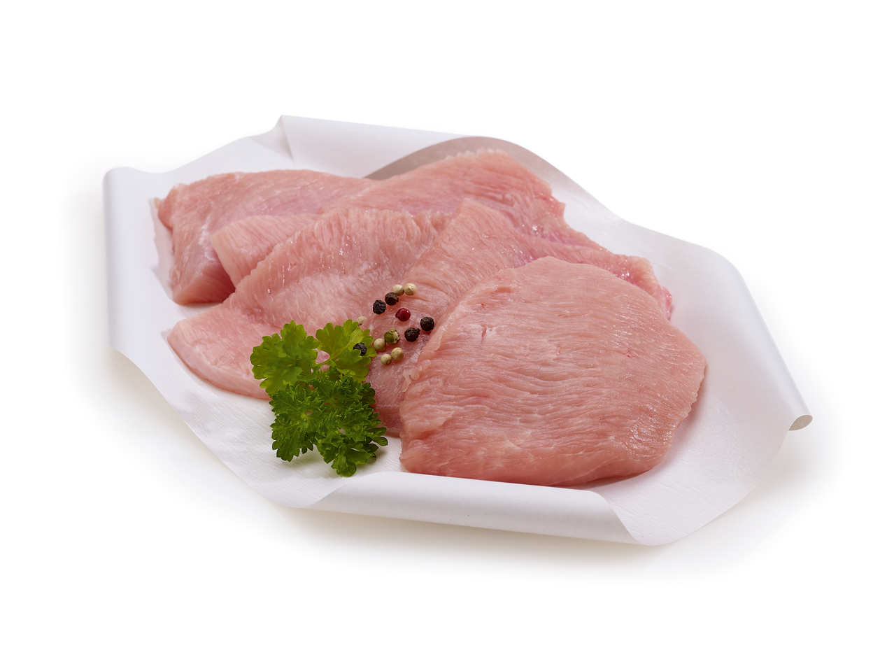 Escalopes de filet de dinde crues avec persil et grains de poivre sur papier blanc.