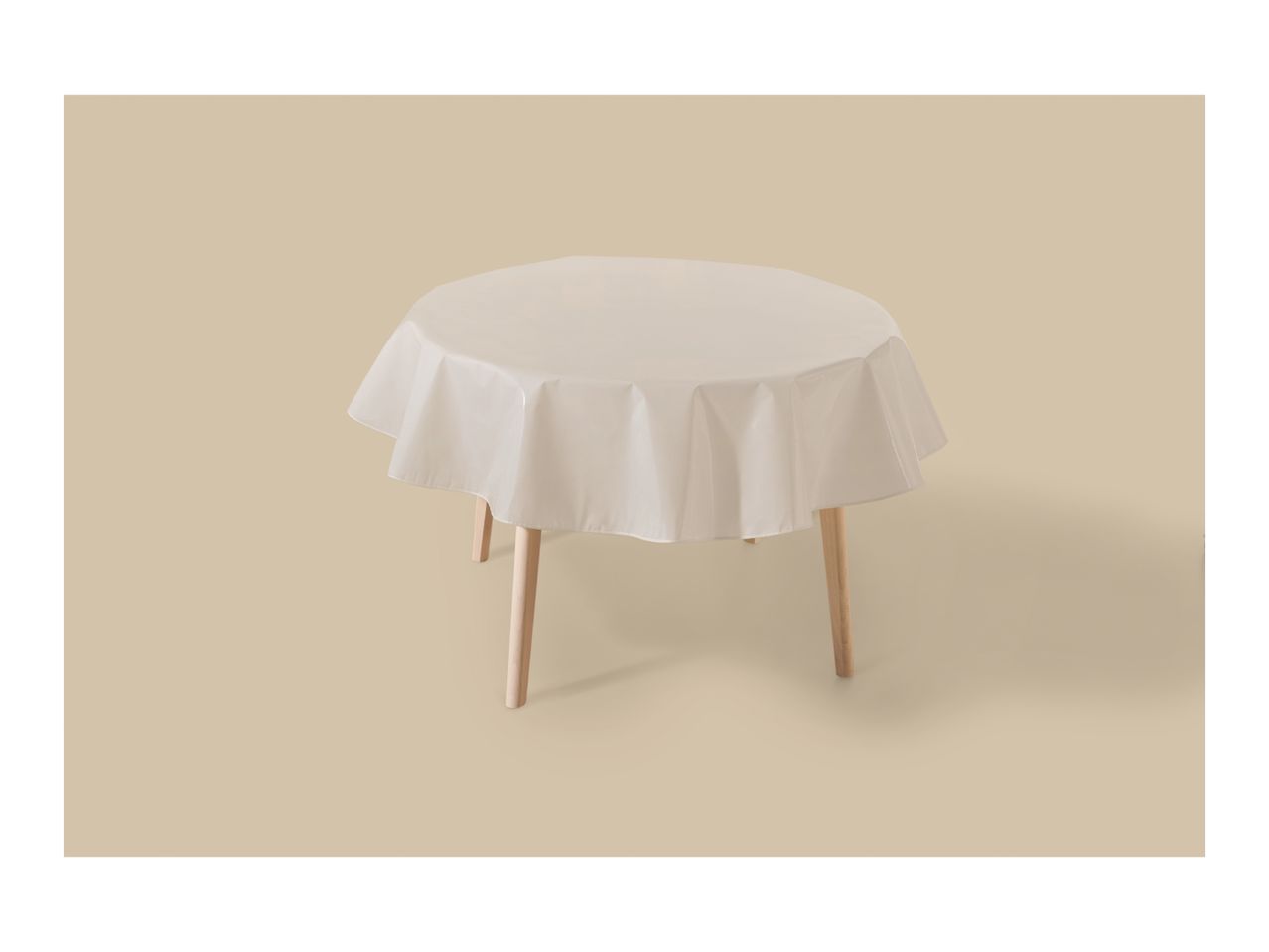 Round table with a light beige tablecloth on a matching background.