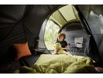 A person relaxes inside a camping tent.