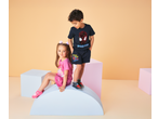 Two children wearing jersey shorts, a boy in Spider-Man shorts and a girl in pink shorts.