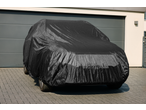 ULTIMATE SPEED® Full Car Cover, black, protecting a car parked on a paved driveway.
