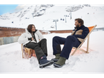 CRIVIT snowboots: Couple sitting in snow, woman in white snowboots, man in green snowboots.