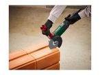 Person using an angle grinder to cut a brick