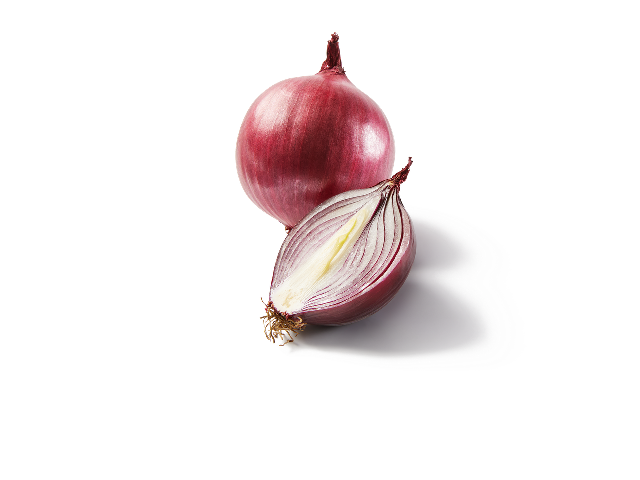 Un oignon rouge entier et un demi-oignon rouge coupé sur fond noir.