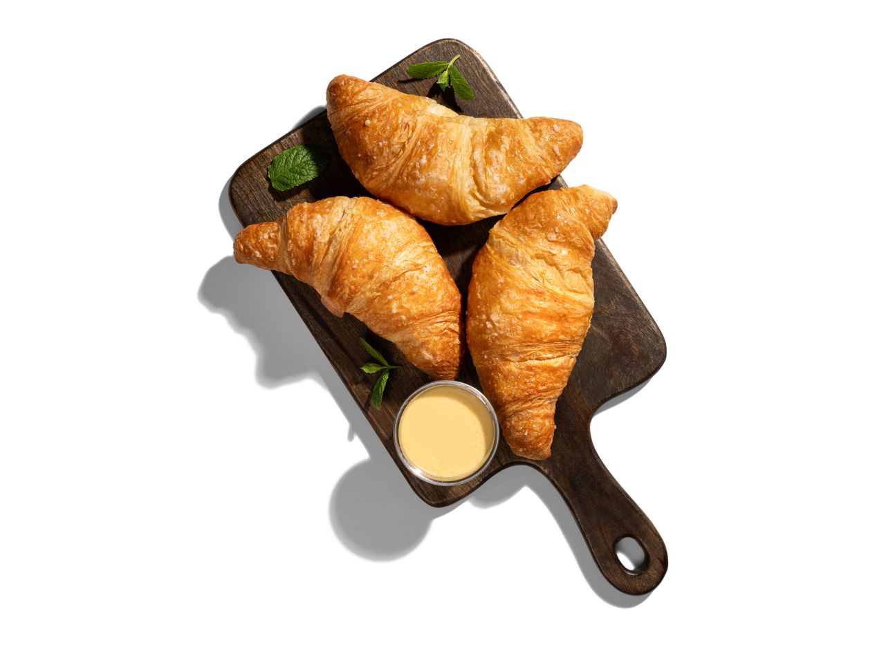 Croissant-ok és szósz fa deszkán.
