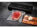 SILVERCREST® vacuum sealer with a vacuum-sealed steak, garlic, and peppercorns on a wooden board.