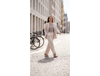 Mulher de blazer e calças ESMARA, a caminhar numa rua de calçada.