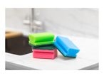 Colorful kitchen sponges on a white marble countertop next to a sink.
