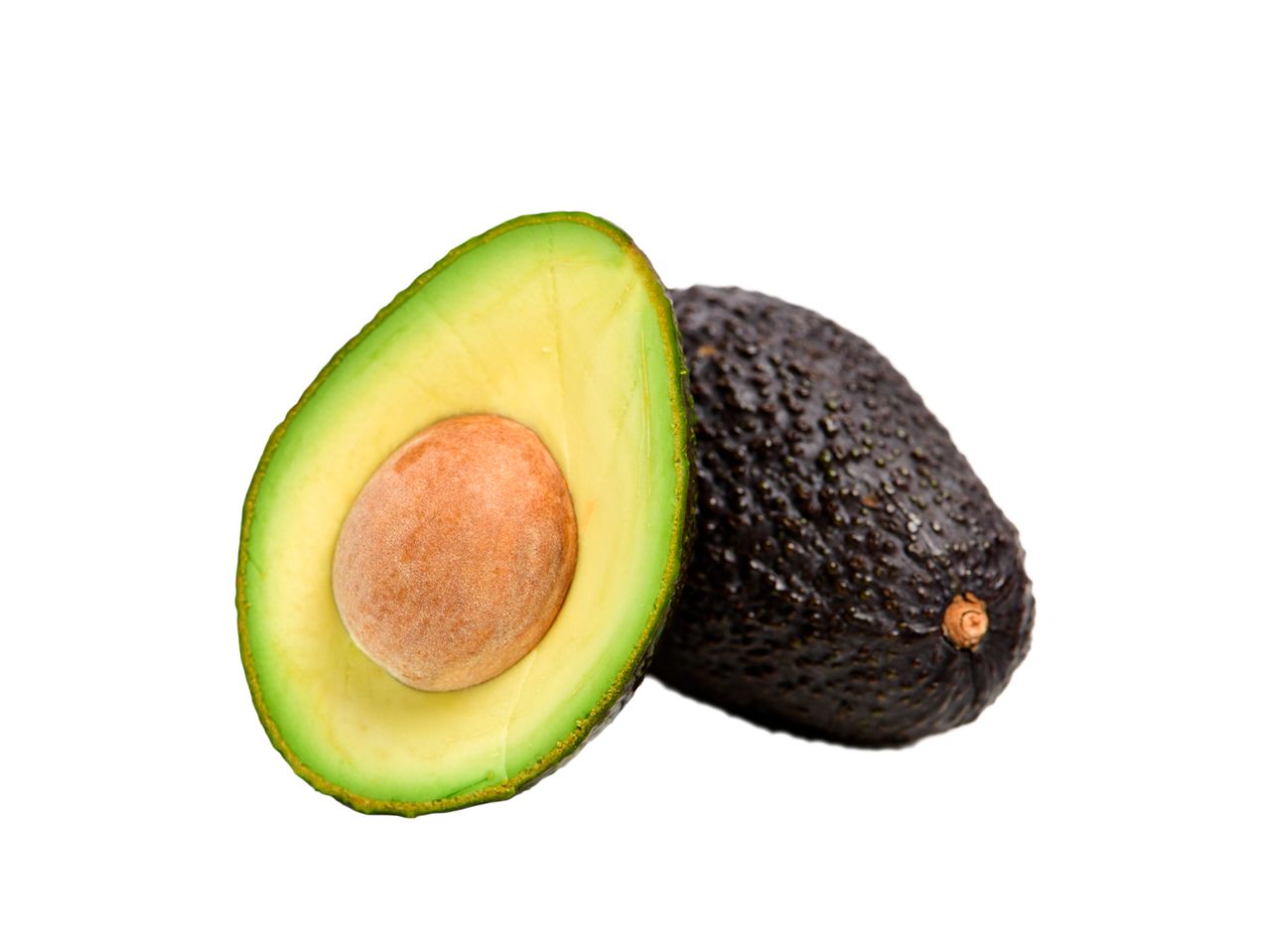A ripe avocado, cut in half, next to a whole avocado.
