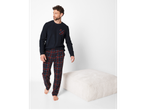 Man in a navy long-sleeved top with a plaid pocket and plaid pajama pants.