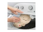 A person placing a plush toy into a washing machine.