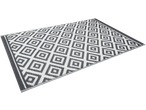 Tapete de exterior com padrão geométrico de losangos em cinzento e branco.