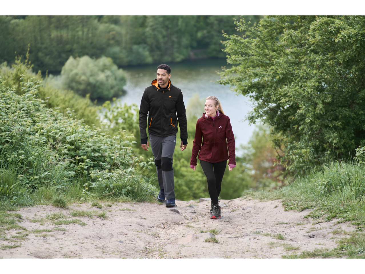 Du žygeiviai su Crivit funkcinėmis striukėmis kaimo take.