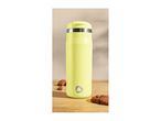 Yellow travel mug with a silver band and logo, next to chocolate chip cookies.