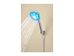 A chrome shower head with blue LED lights spraying water against a beige wall.