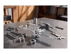 Tap and die set with various taps, dies, and tap wrenches on a metal workbench.