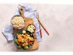 Ginger stir-fry with chicken, broccoli, carrots, and brown rice, served with chopsticks.