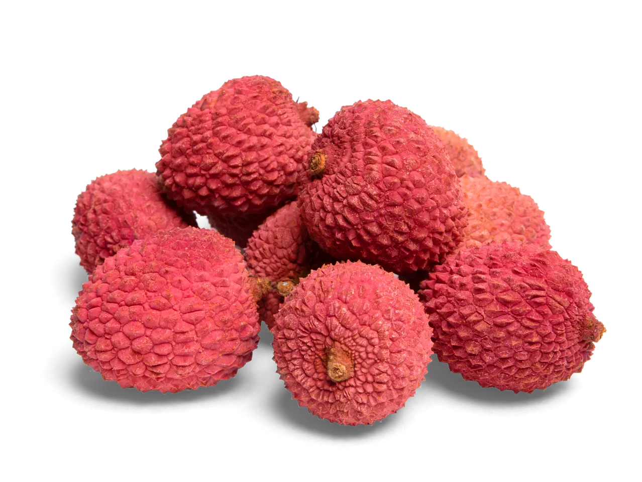 Een stapel verse, rode lychees met een ruwe schil op een zwarte achtergrond.