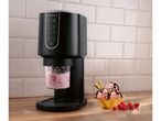 Ice cream maker with a clear container of pink mixture, next to a waffle bowl with ice cream.