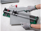 Cutting tiles with a manual tool: tiles and a tile cutter.