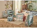 Cameră de copii cu tematică forestieră, mobilier albastru deschis, depozitare și un pat cu baldachin.