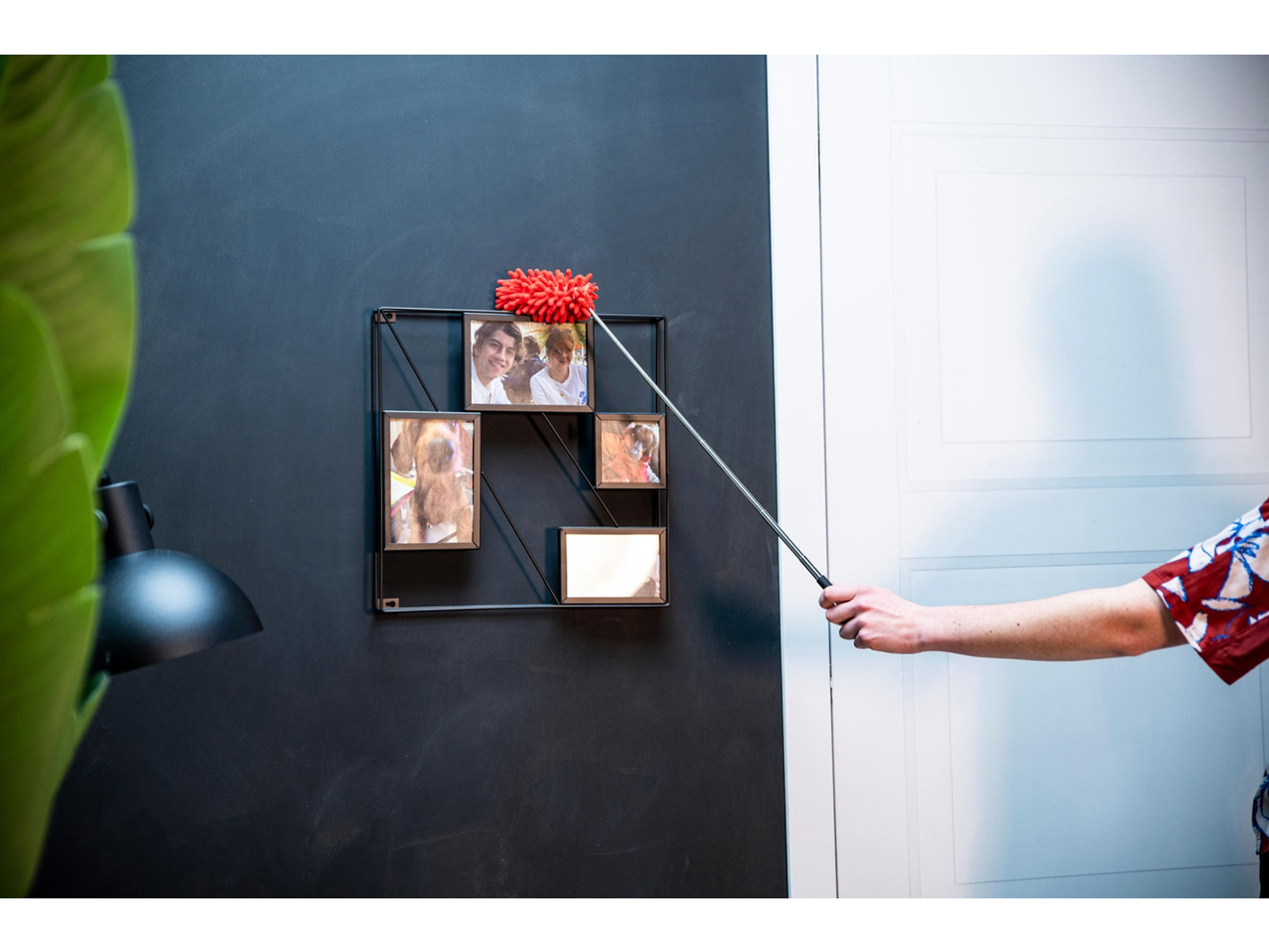 Homem a limpar uma moldura com um espanador Dirt Devil.